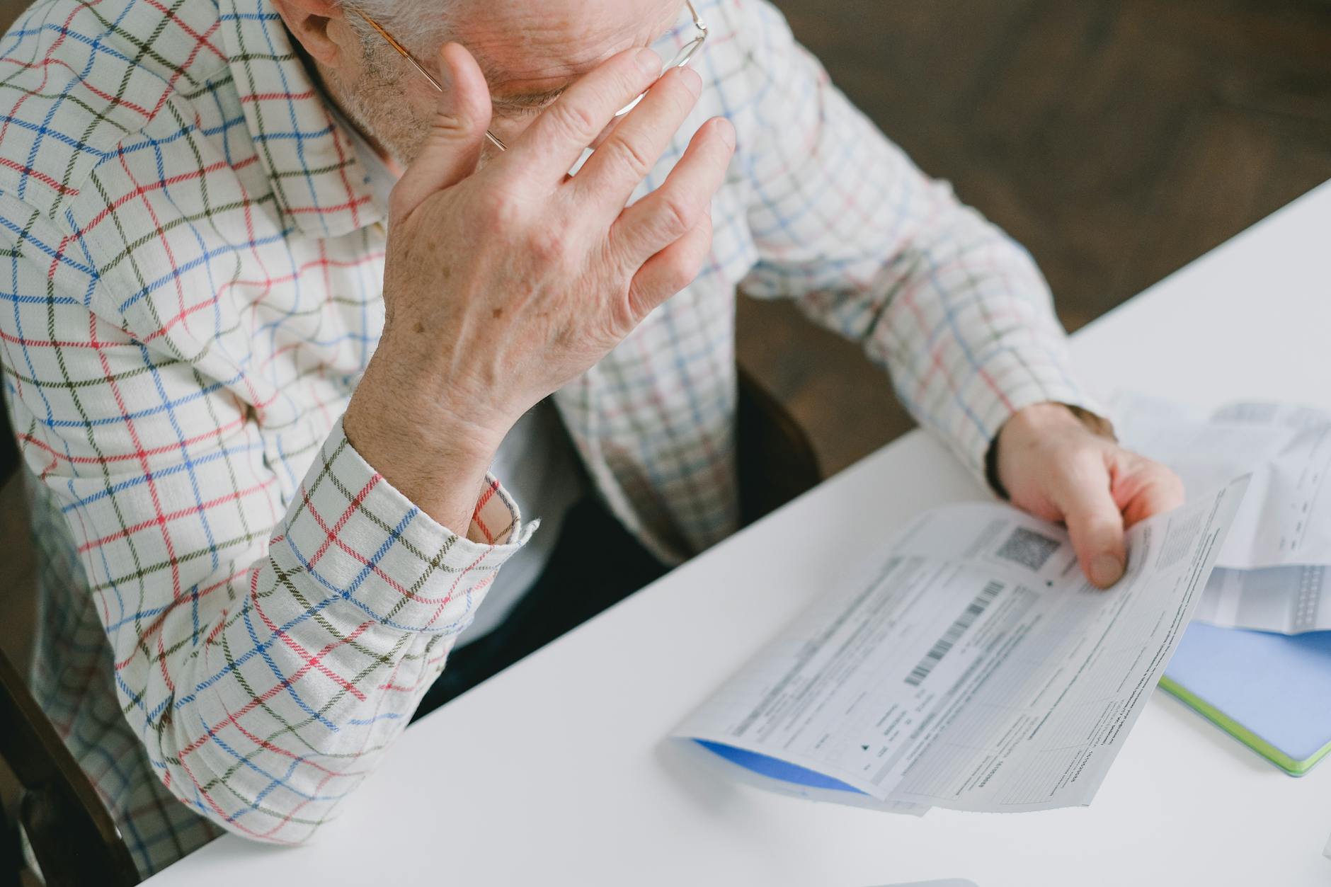 a high angle shot of an elderly man holding a paper