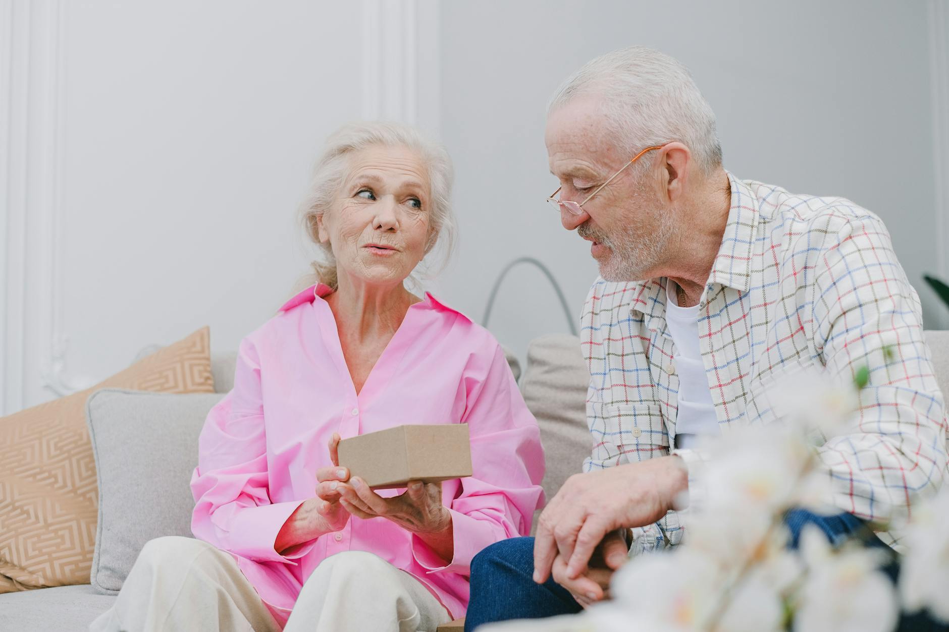 an elderly couple looking at a box together