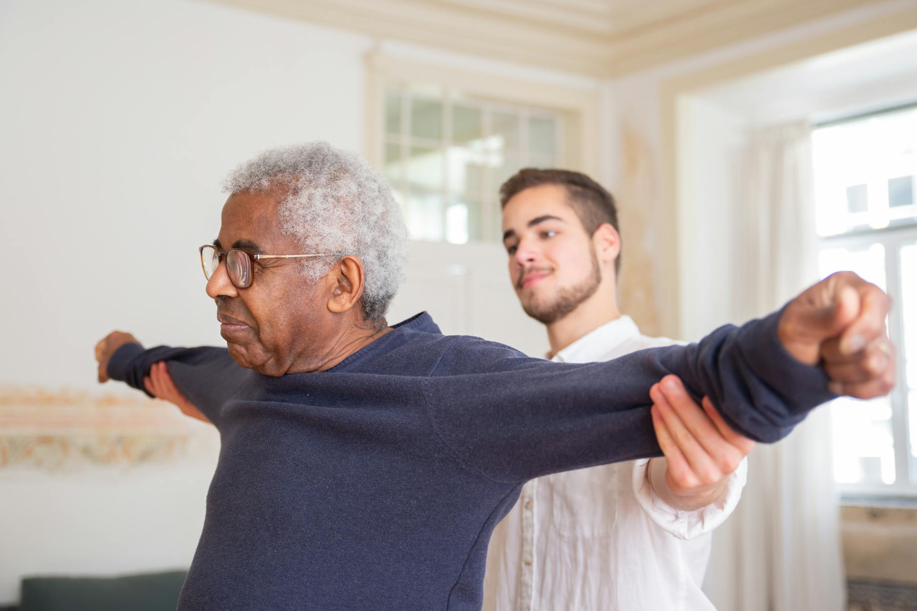 a man in blue sweater wearing eyeglasses doing exercise