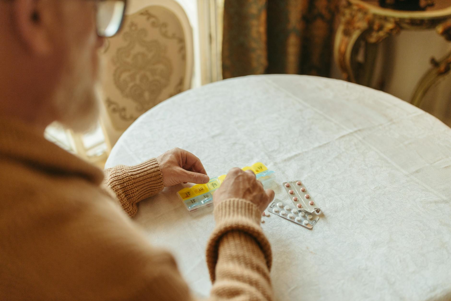 person in knitted sweater organizing the medicines