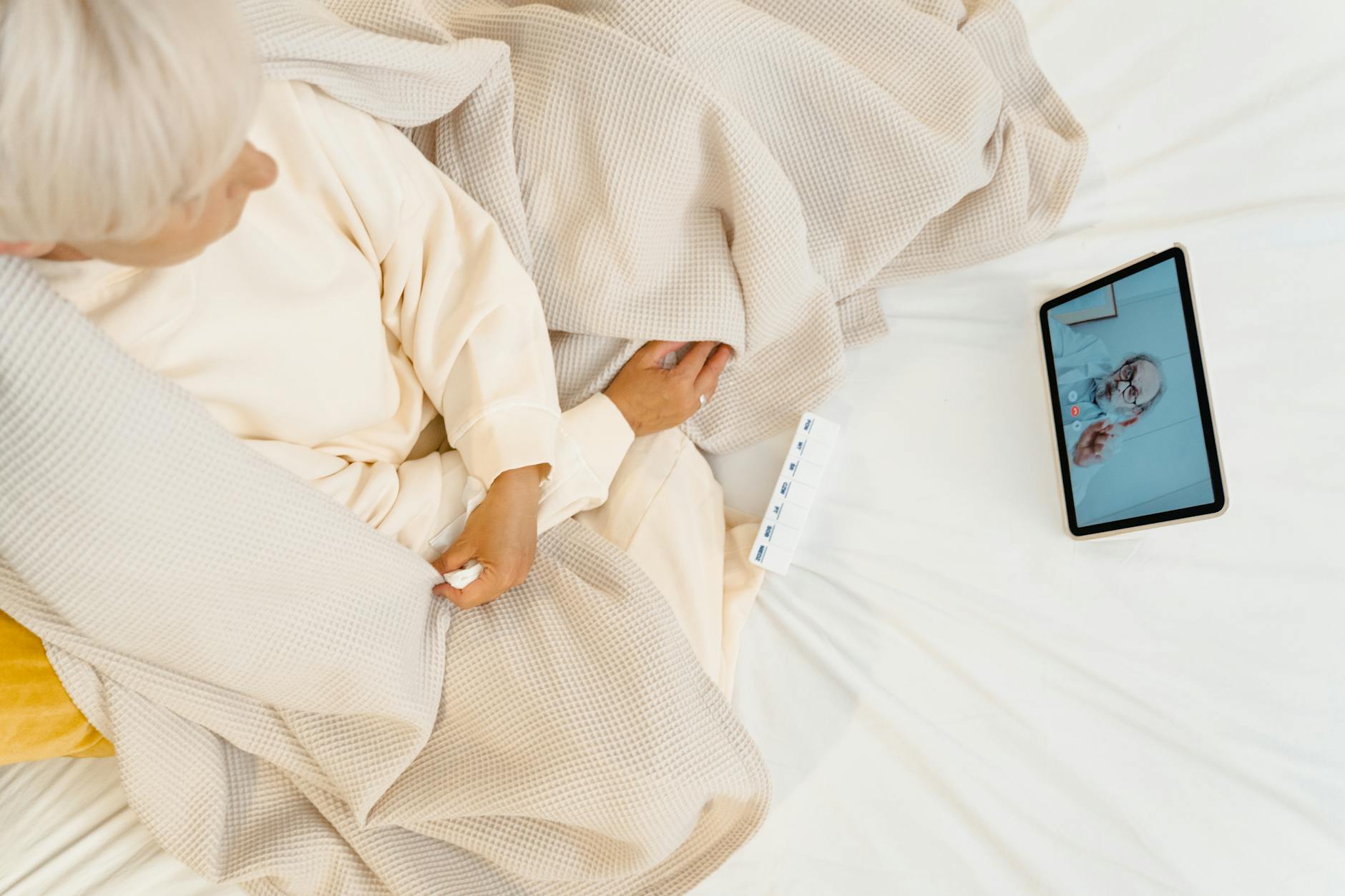 person sitting on bed while having a video call