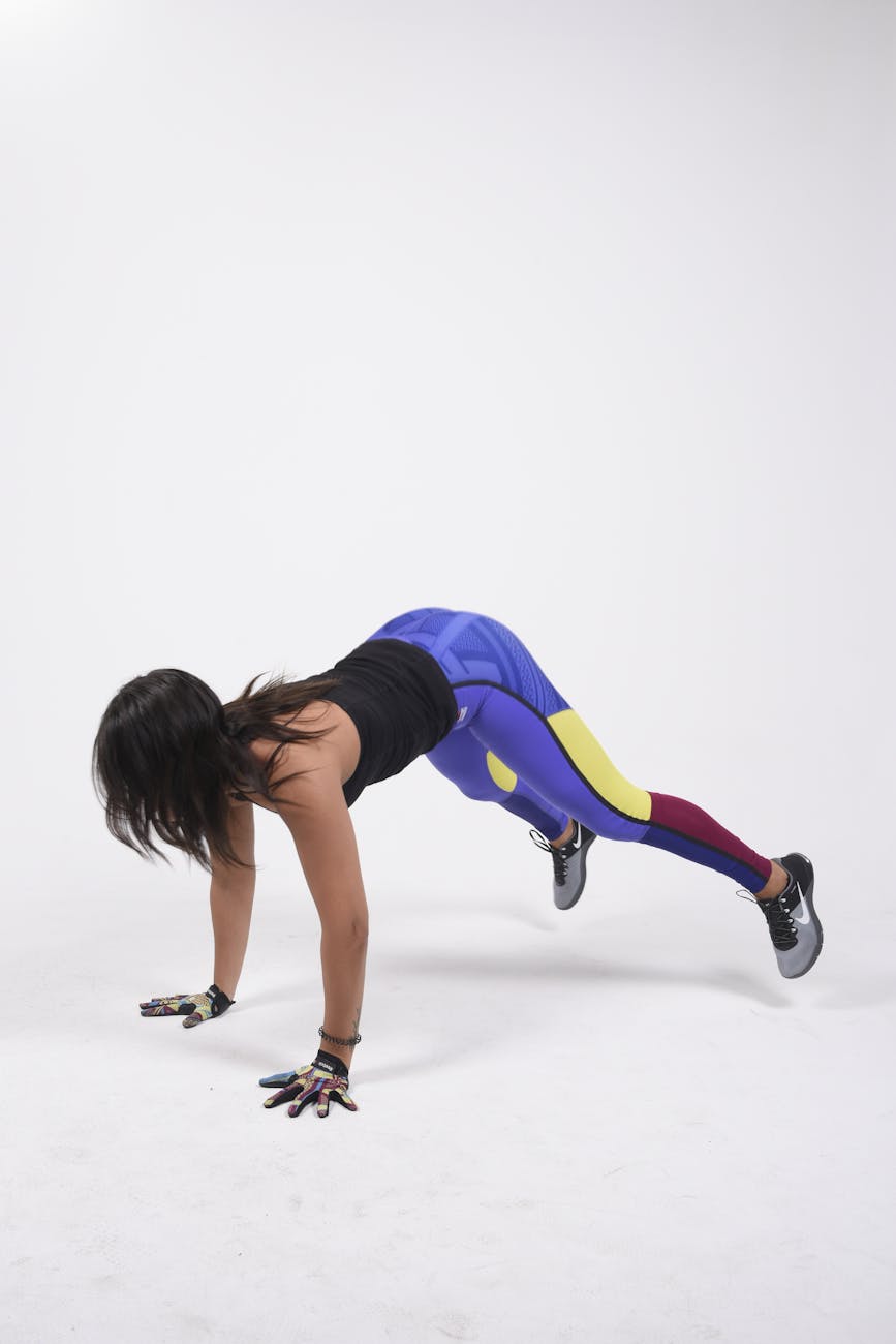 female athlete performing burpee in studio setting