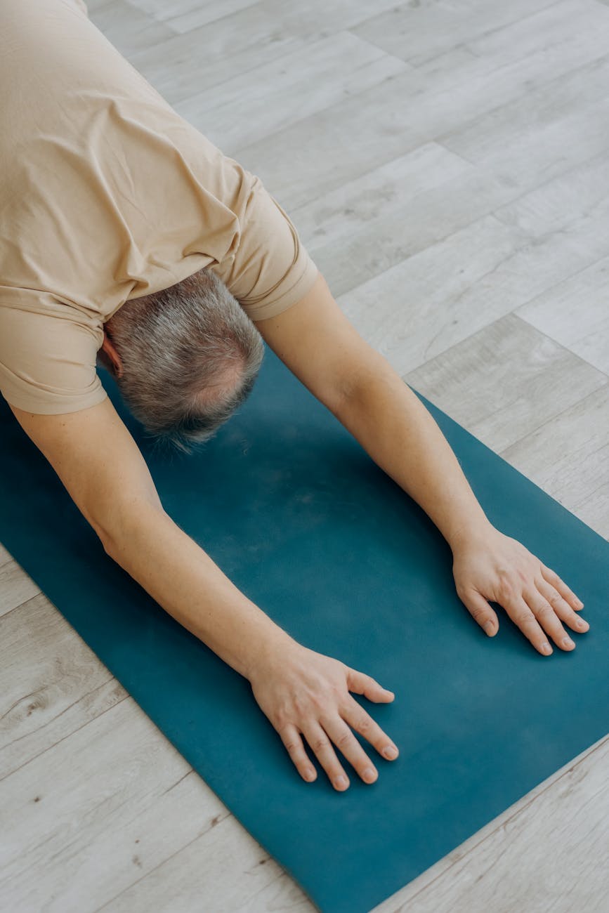 man in beige shirt doing a forward bend