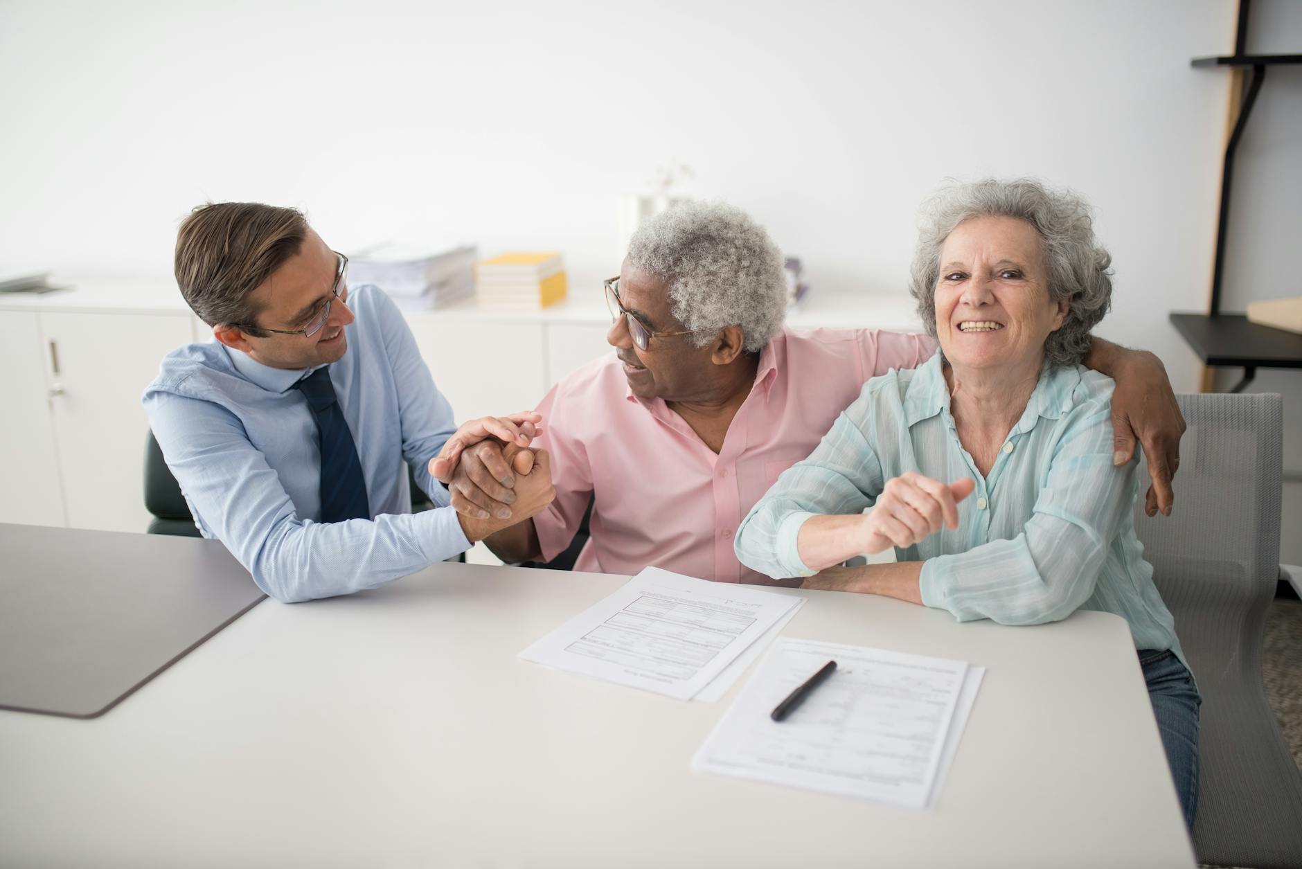 insurance agent sitting next to smiling clients