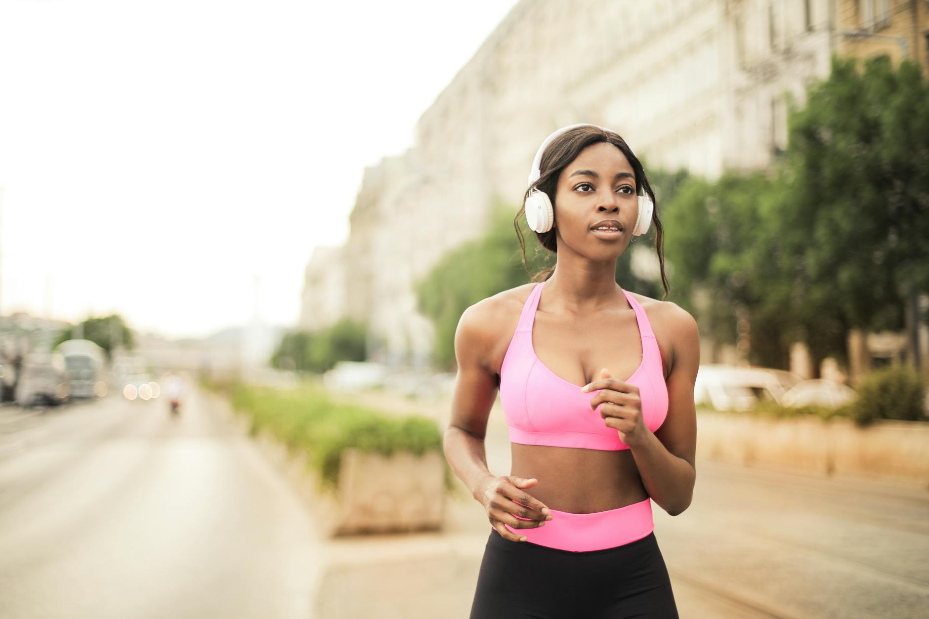 woman in pink sports bra and black leggings jogging