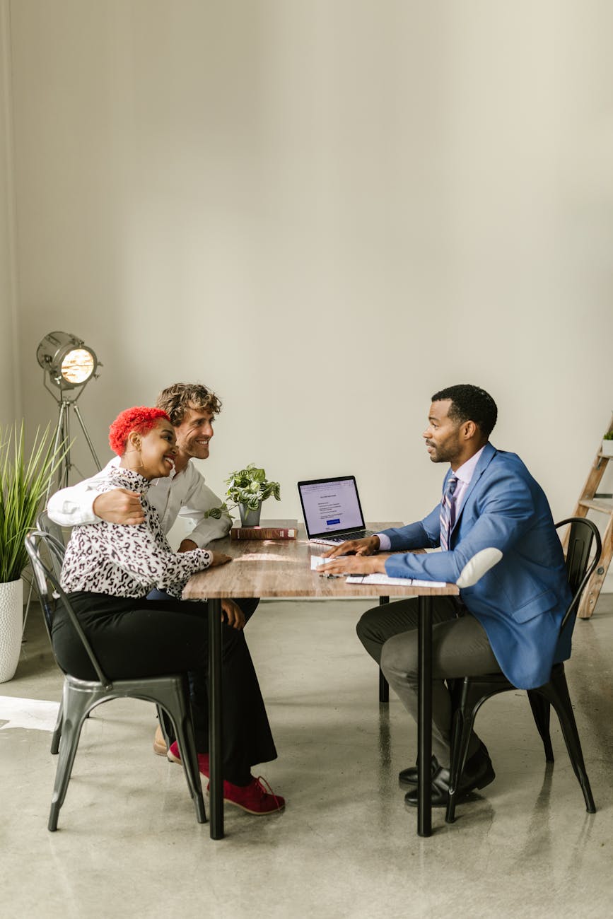 man and woman sitting on chair in front of laptop computer