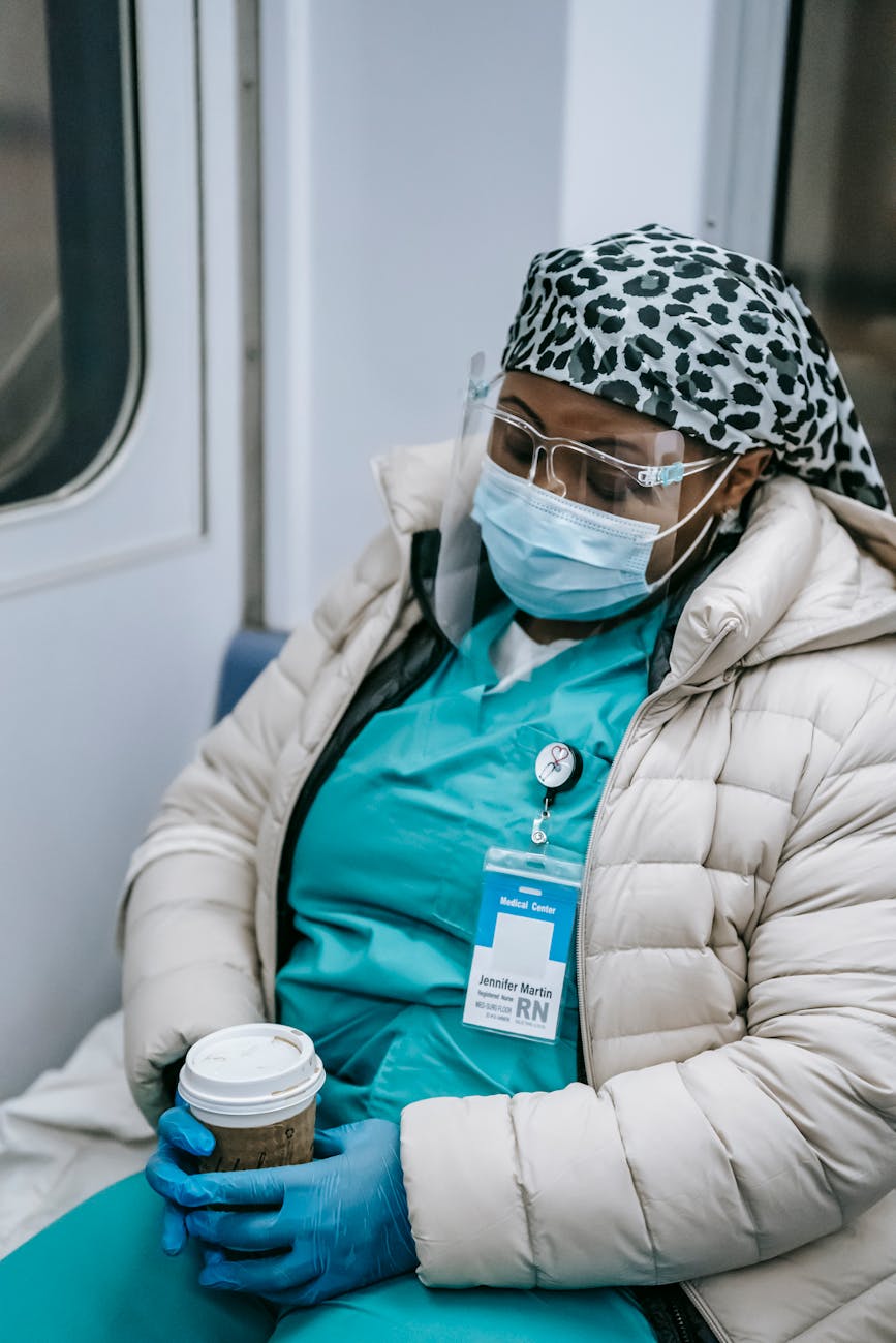 tired black nurse in mask sleeping in metro train