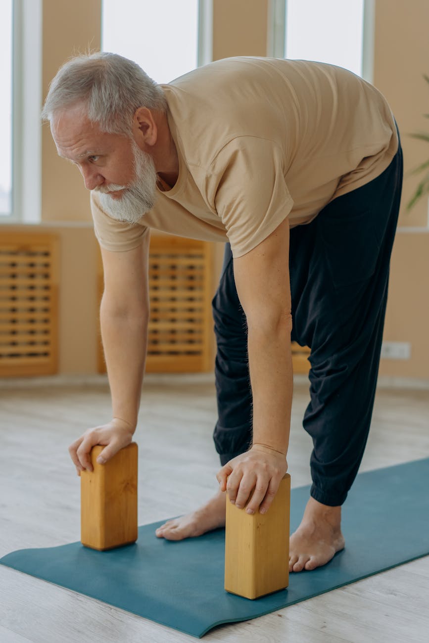 a man bending forward and holding wooden blocks