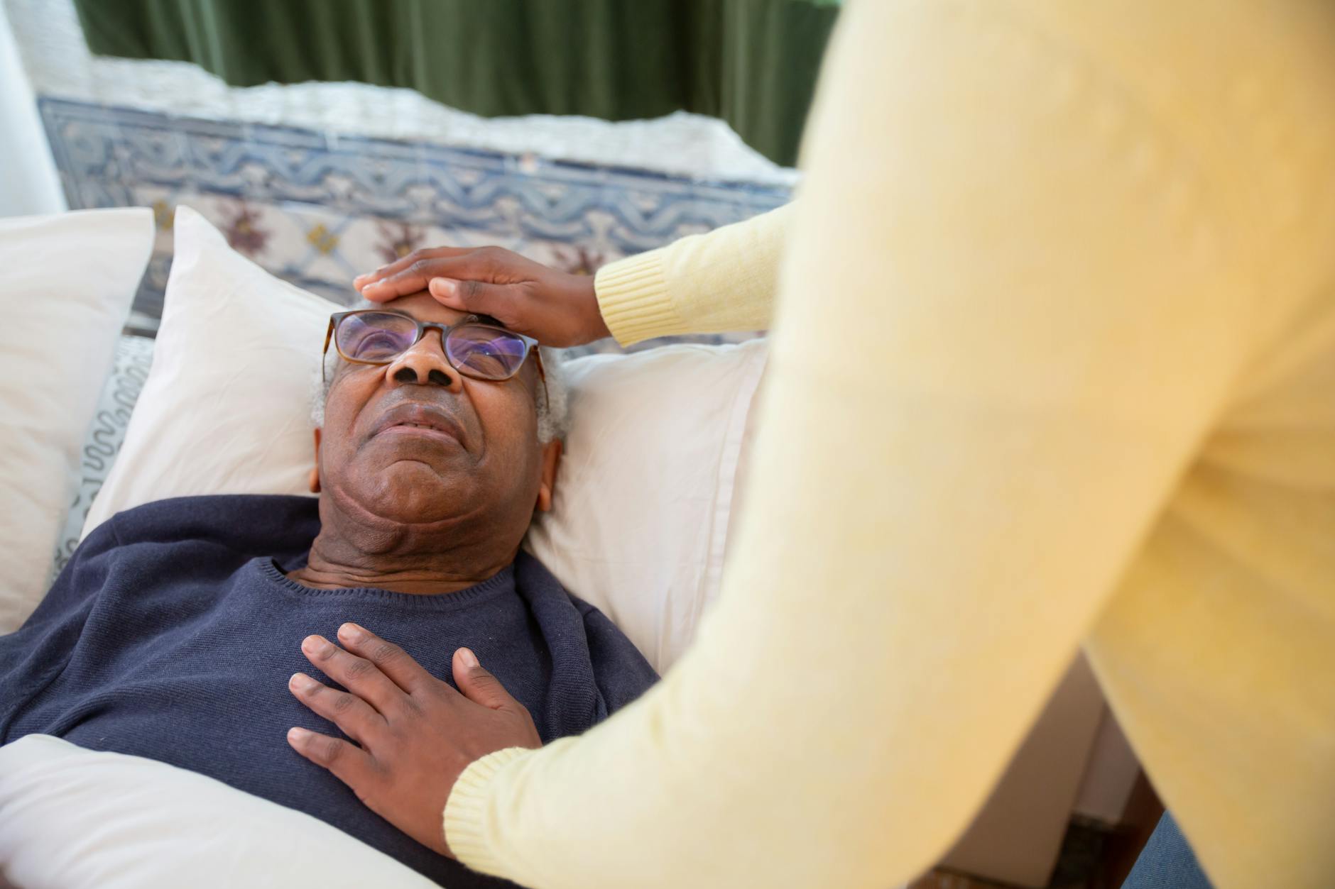 a man in blue sweater lying on the bed